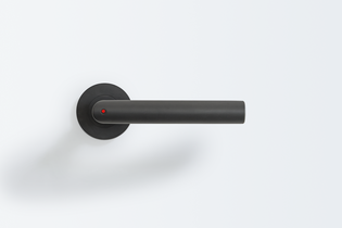 The picture shows the Griffwerk door handle Lucia smart2lock in graphite black from the outside. A red dot on the door handle shows that the door is locked.